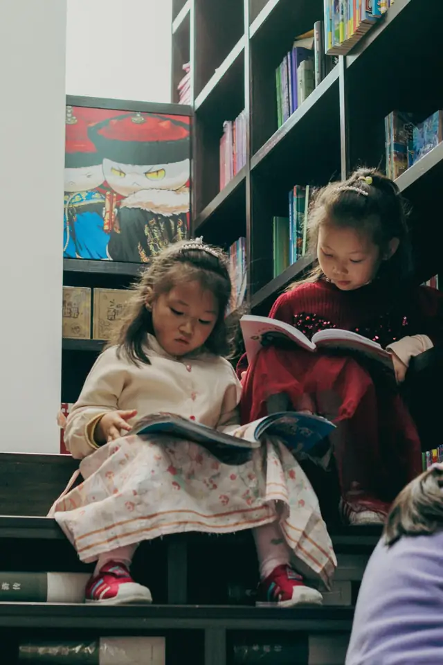Two girls reading books on the stairs